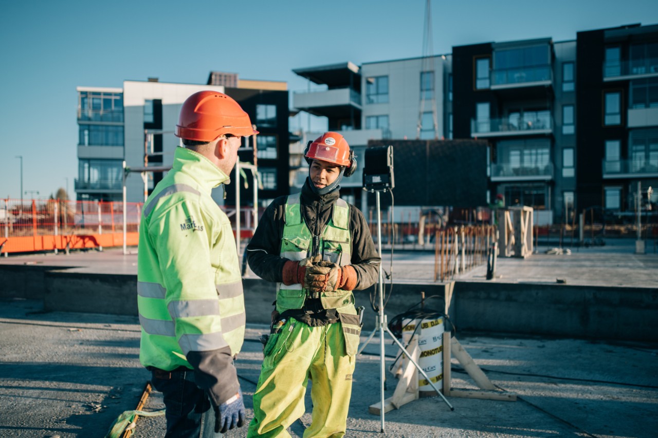 bygningsarbeidere står på taket av en bygning med verktøy og utstyr